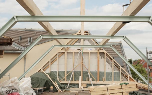 Metallbalken stützen eine neue Dachkonstruktion im Altbau.