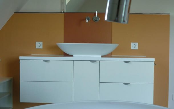 Bad mit Waschbecken vor orangenem Hintergrund.