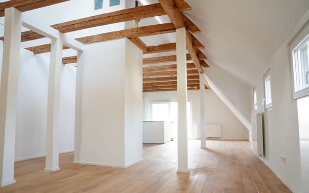 Wohnzimmer mit freiliegenden Dachbalken und Holzboden.