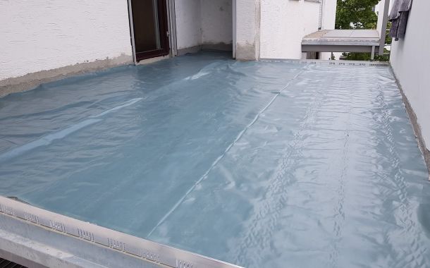 Terrassansanierung: Terrasse mit blauer Schutzfolie abgedeckt w&auml;hrend Abdichtungsarbeiten