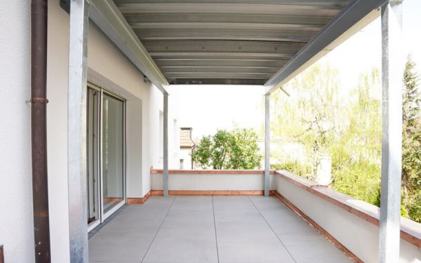 Terrasse nach der Sanierung mit hellgrauen Fliesen.