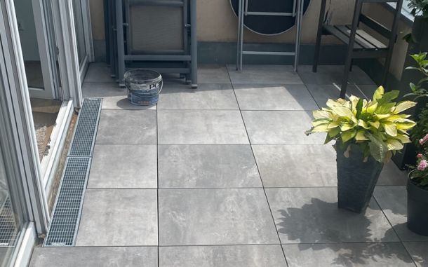 Fertig verlegte Terrassenplatten in hellgrau.
