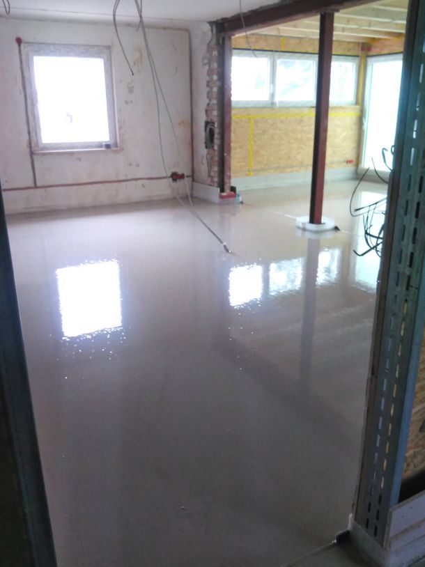 Frisch verlegter gl&auml;nzender Estrichboden in einem sanierten Geb&auml;ude.